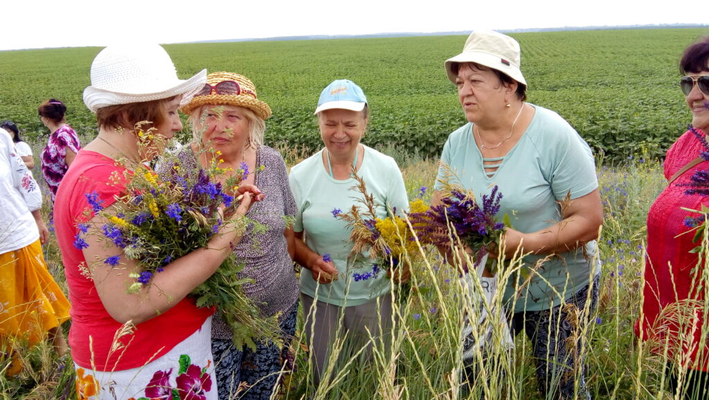 Учасниці мандрівки збирають польові квіти для купальських вінків у Куземині